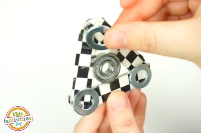 Add Weight to Fidget Spinner craft - washers glued to each corner with fingers placing them properly