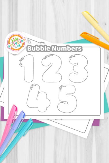 Black and white printed bubble numbers 0-9 on top of blue-green and purple sheets with assorted markers on a dark grey background. printed pdf version from Kids activities blog.
