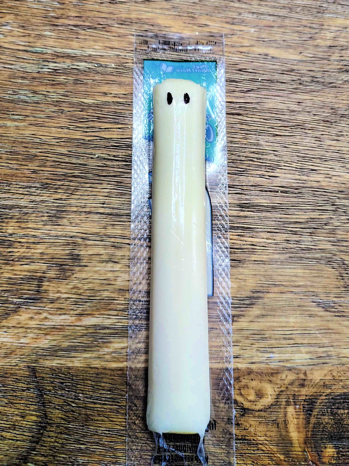 Christmas Snacks Craft- Step 6- Two eyes drawn on the backside of the cheese wrapper for string cheese- Kids Activities Blog