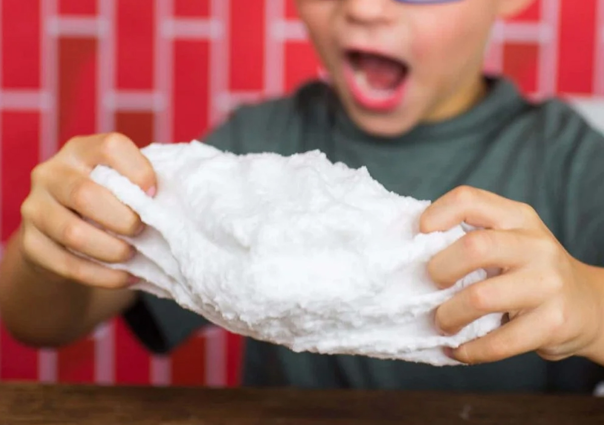 A kid playing with DIY fluffy slime.