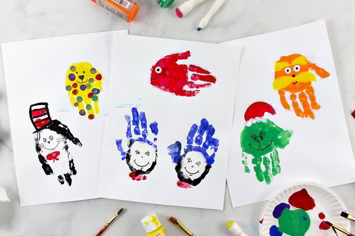 Dr Seuss Birthday craft - handprint art that look like Dr Seuss characters like cat in the hat, grinch and more shown on paper with paint supplies