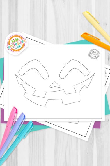 Black and white pumpkin faces outline template printable on top of blue-green and purple sheets with assorted markers on a dark grey background. printed pdf version from Kids activities blog.