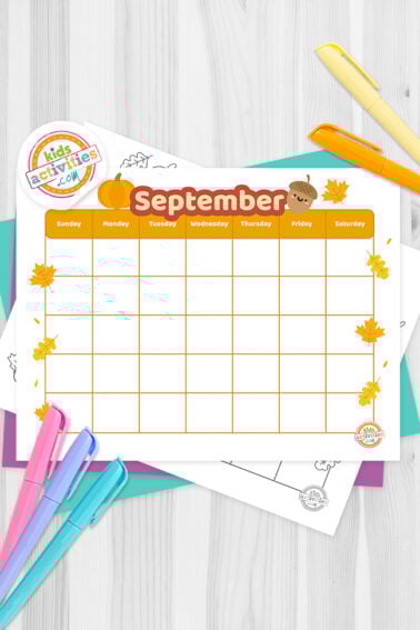 Black and white September calendar printable decorated with autumn designs such as clouds, and a leaves; lying on top of a blue-green sheet with multicolored letters on a light gray background.