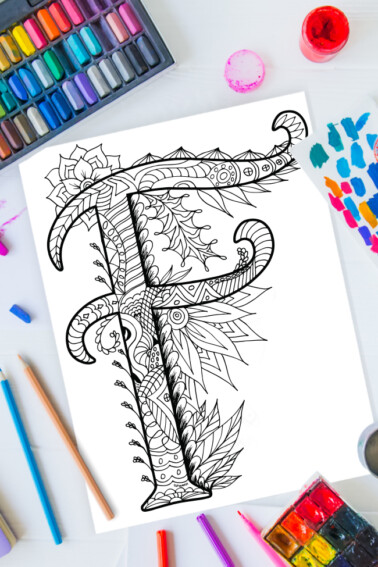 Zentangle alphabet coloring pages - letter f zentangle design on background of paint, colored pencils and art supplies