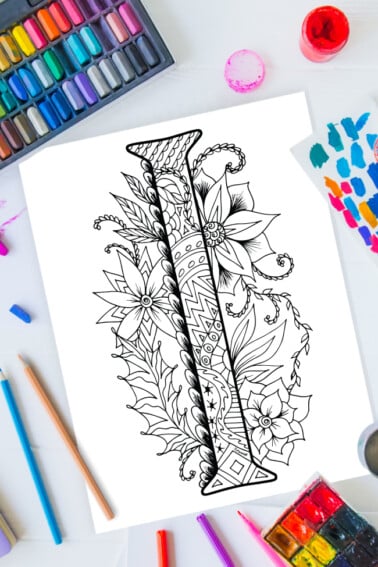 Zentangle alphabet coloring pages - letter I zentangle design on background of paint, colored pencils and art supplies