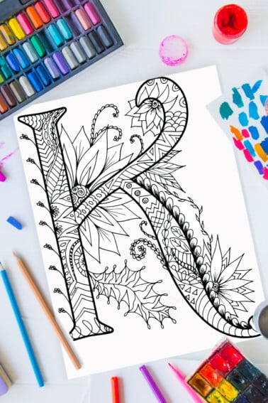 Zentangle alphabet coloring pages - letter k zentangle design on background of paint, colored pencils and art supplies